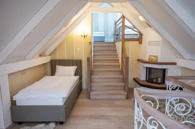 a bedroom with a bed and a staircase at Apartmaji Hiša kranjske čebele in Višnja Gora