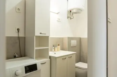 a small bathroom with a sink and a toilet at Urban NEST apartment - FREE Parking & Central in Kočevje