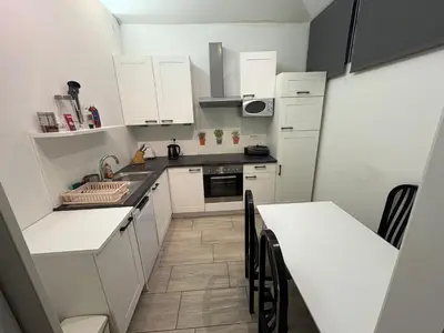 a small kitchen with white cabinets and a counter top at Industrial studio 5 in Ljubljana