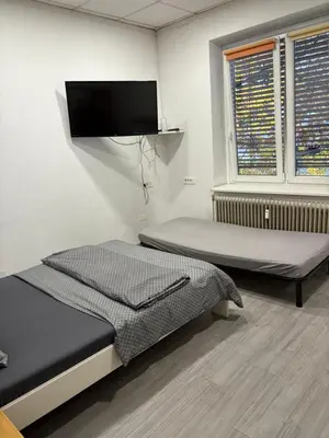 a bedroom with two beds and a flat screen tv at Industrial studio 5 in Ljubljana