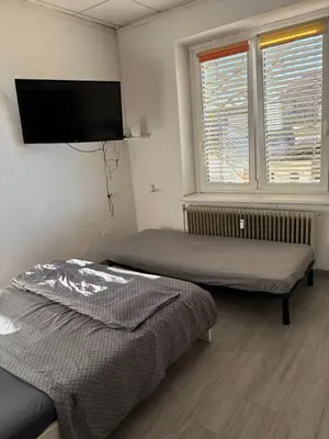 a bedroom with two beds and a flat screen tv at Industrial studio 5 in Ljubljana