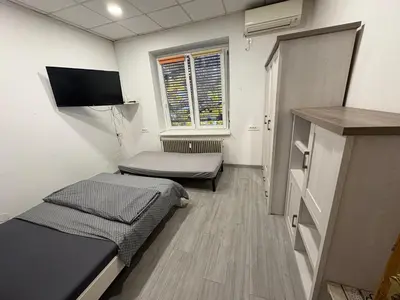 a small room with two beds and a window at Industrial studio 5 in Ljubljana