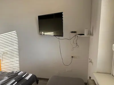 a flat screen tv hanging on the wall of a bedroom at Industrial studio 5 in Ljubljana