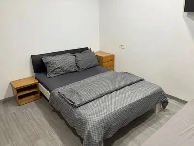 a bedroom with a bed with a gray comforter at Industrial studio 5 in Ljubljana