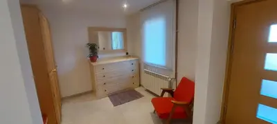 a bedroom with a dresser and a red chair at Apart House ROJER in Ljubno