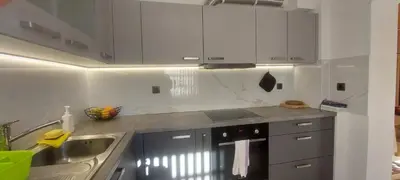 a kitchen with white cabinets and a sink at Apart House ROJER in Ljubno