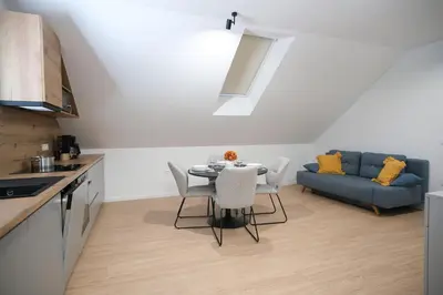 a kitchen with a table and a blue couch at Apartma Eva in Krško