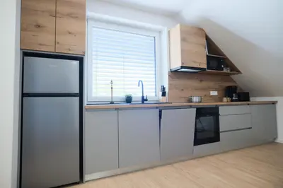 a kitchen with white cabinets and a window at Apartma Eva in Krško