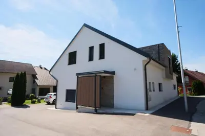 a white house with a garage in a driveway at Apartma Eva in Krško