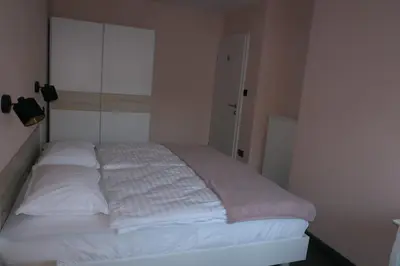 a bedroom with a bed with white sheets at Apartment Golovec in Ljubljana