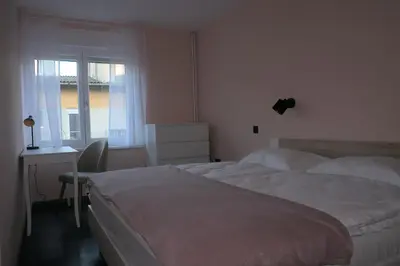 a bedroom with two beds and a desk and a window at Apartment Golovec in Ljubljana