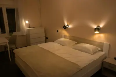 a bedroom with a white bed with lights on it at Apartment Golovec in Ljubljana