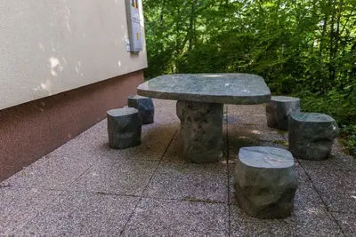 a stone bench and stools sitting next to a building at Holiday Home Lemut in Kranj