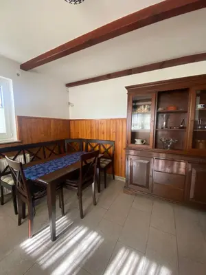 a dining room with a table and wooden cabinets at Holiday Home Lemut in Kranj