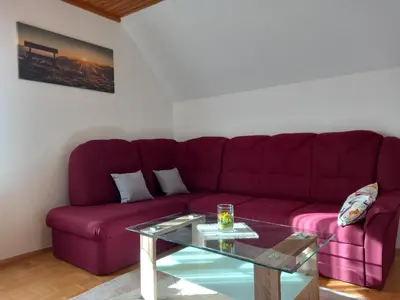 a living room with a purple couch and a glass table at Apartma Melita in Rovte