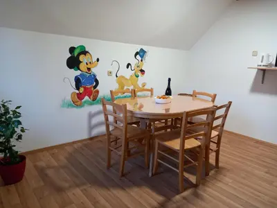 a dining room table and chairs with a painting on the wall at Apartma Melita in Rovte