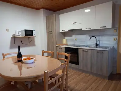 a kitchen with a table with a bottle of wine at Apartma Melita in Rovte