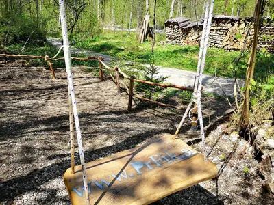 a wooden swing in the middle of a forest at PR`FIK Apartments in Kranj