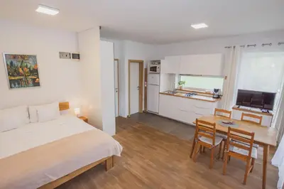 a bedroom with a bed and a table and a kitchen at PR`FIK Apartments in Kranj