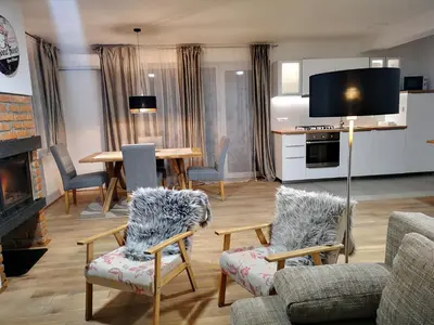 a living room with a table and chairs and a kitchen at PR`FIK Apartments in Kranj