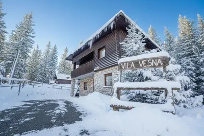 a building with a sign in the snow at Vila Vesna in Zgornje Gorje