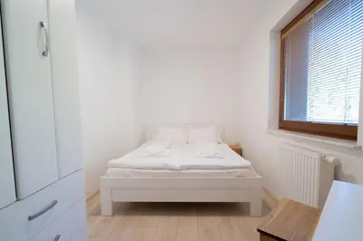 a white bed in a room with a window at Vila Vesna in Zgornje Gorje