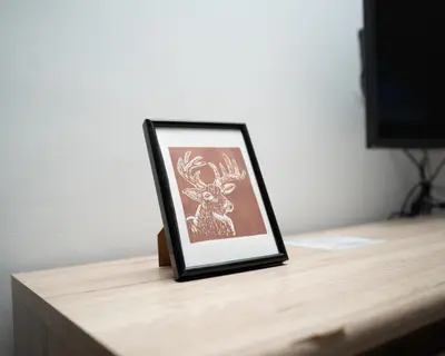 a picture of a deer in a frame on a table at Vila Vesna in Zgornje Gorje