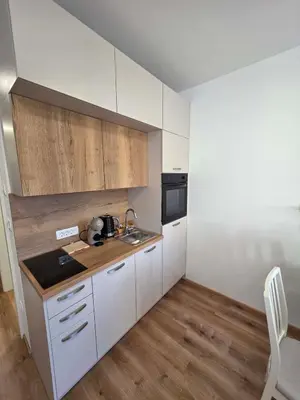 a kitchen with white cabinets and a wooden floor at Vila Brod in Ljubljana