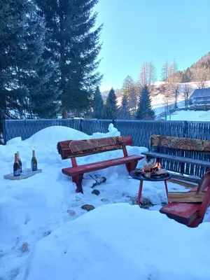 a snow covered yard with two benches and a fire pit at Apartment Tarman in Jesenice