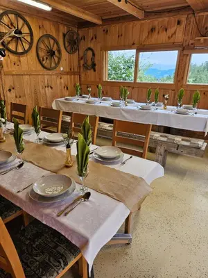 a dining room with tables and chairs and windows at Turistična kmetija Sušek in Muta