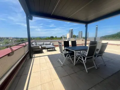 a patio with a table and chairs on a roof at Stunning Terrace in Ljubljana