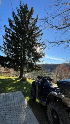 a atv parked in front of a tree at Cosy house Na Robu in Grgar