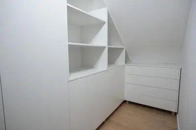 a white closet with white shelves in a room at Apartma Ana in Krško