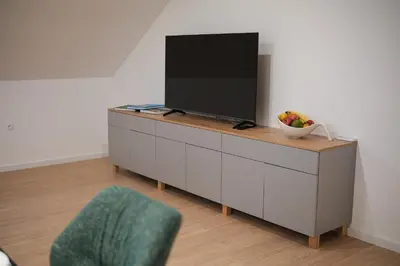 a tv on a cabinet with a bowl of fruit on it at Apartma Ana in Krško