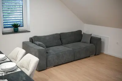 a living room with a gray couch and a table at Apartma Ana in Krško