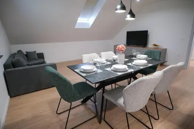 a dining room table and chairs in a living room at Apartma Ana in Krško
