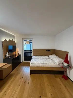 a large bedroom with a bed and a television at Mounti Alpine Studio in Kranjska Gora
