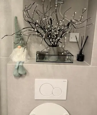 a bathroom with a toilet and a vase with branches at Mounti Alpine Studio in Kranjska Gora