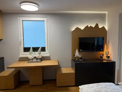 a bedroom with a bed and a desk and a window at Mounti Alpine Studio in Kranjska Gora