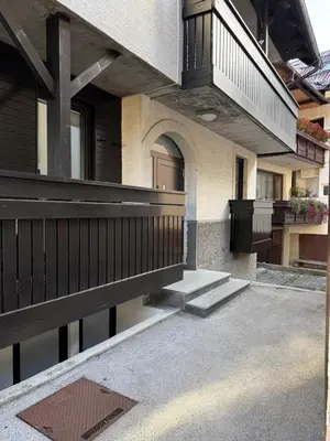 a house with a wooden fence and a balcony at Mounti Alpine Studio in Kranjska Gora