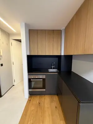 a kitchen with a black counter top and wooden cabinets at Mounti Alpine Studio in Kranjska Gora
