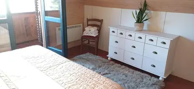 a bedroom with a bed and a dresser with a plant on it at House Planinka in the heart of nature in Ljubno