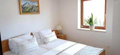 a bedroom with a bed with white pillows and a window at House Planinka in the heart of nature in Ljubno