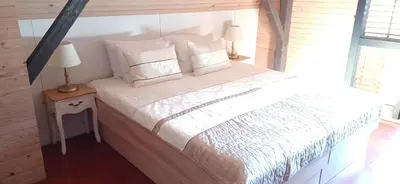 a bedroom with a bed with white sheets and pillows at House Planinka in the heart of nature in Ljubno