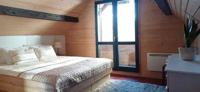 a bedroom with a bed and a large window at House Planinka in the heart of nature in Ljubno