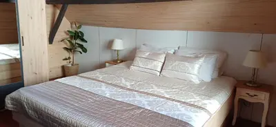 a bedroom with a bed with white sheets and pillows at House Planinka in the heart of nature in Ljubno
