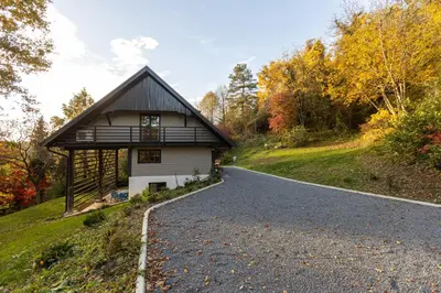 a house on a hill next to a road at Hiša Jaglenka in Ponikva