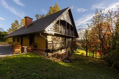 a small house with a porch on the grass at Hiša Jaglenka in Ponikva