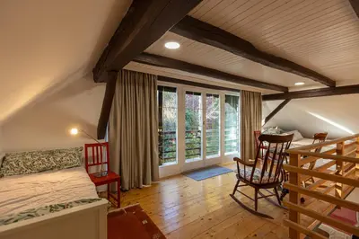 a bedroom with a bed and a table and chairs at Hiša Jaglenka in Ponikva