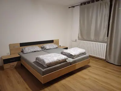 a bedroom with two beds and a large window at KaTi Hiša